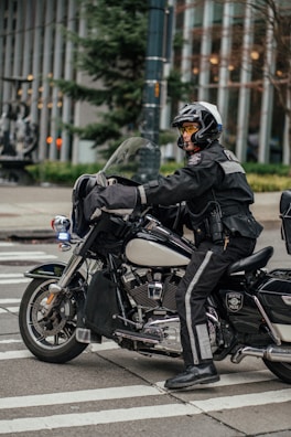 a man riding on the back of a motorcycle down a street