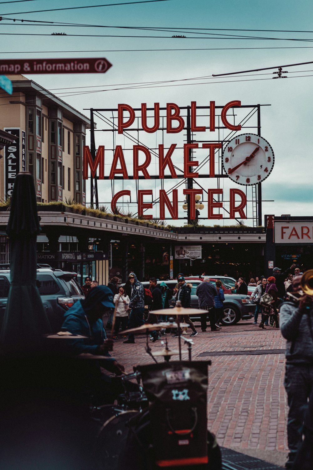 a crowd of people walking down a street next to a market