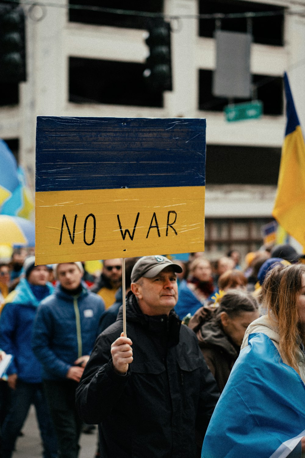 a man holding a sign that says no war