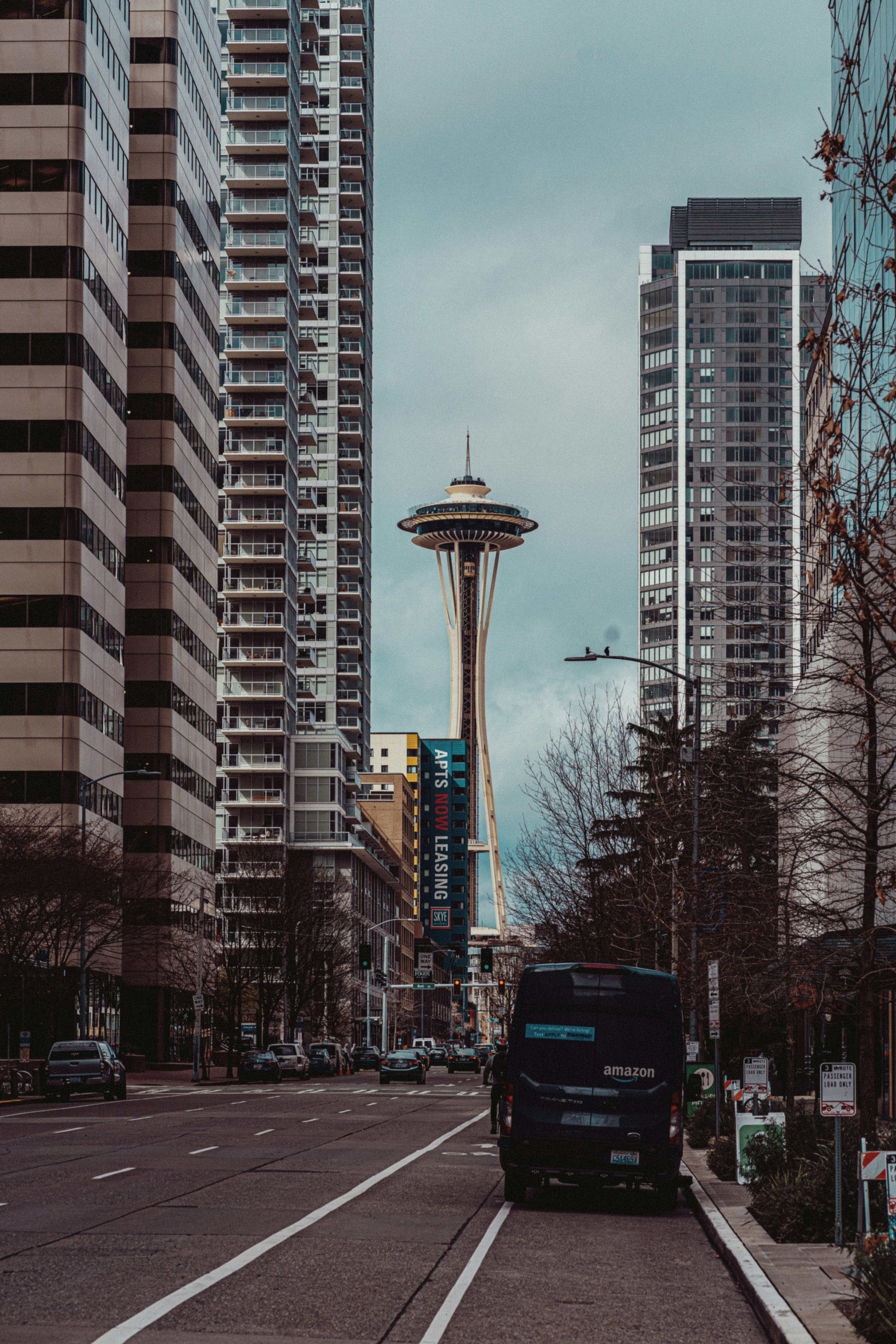 a black van driving down a street next to tall buildings