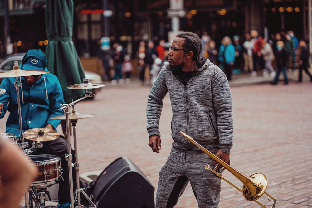 a man standing next to a drum set on a street