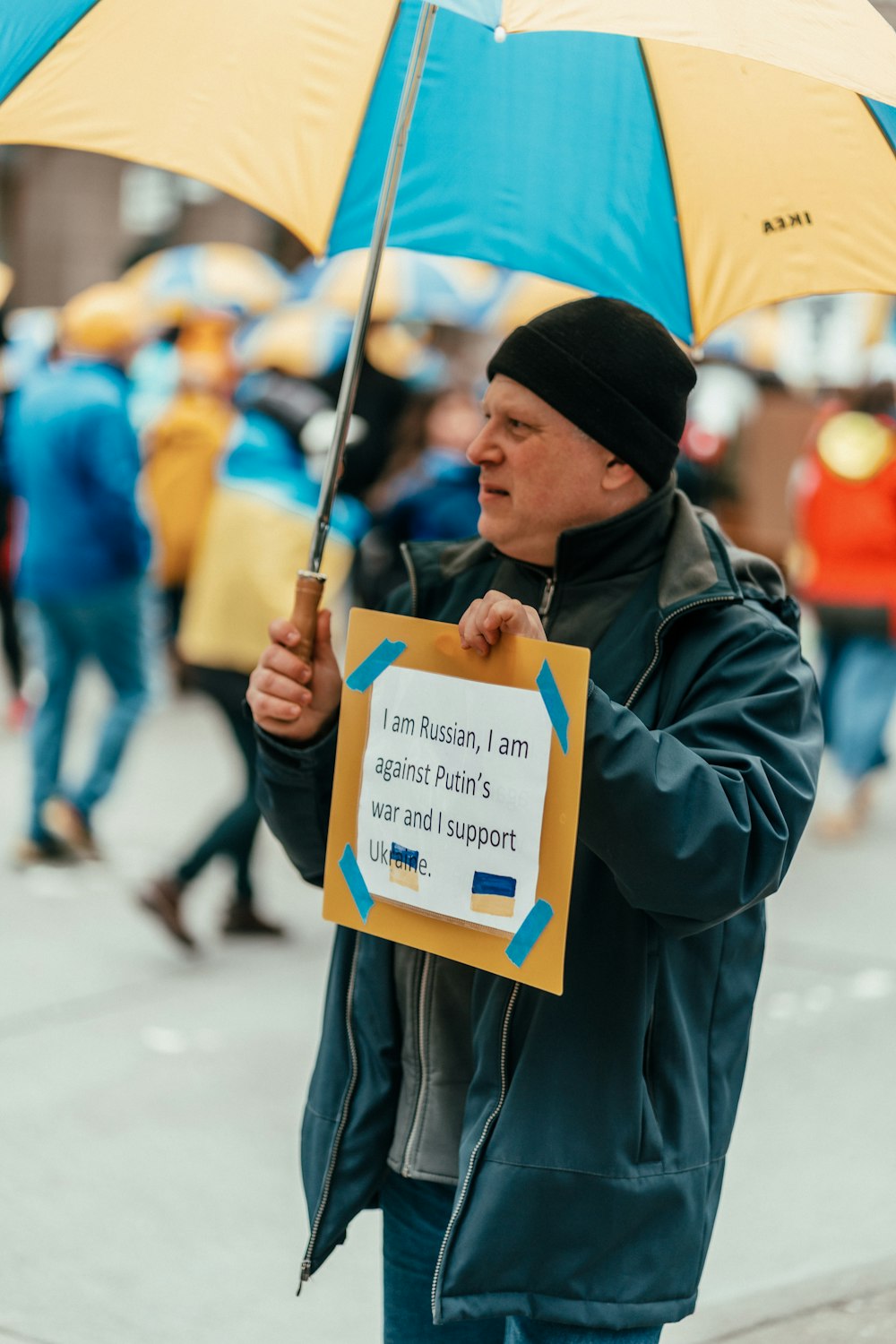 a man holding a yellow and blue umbrella