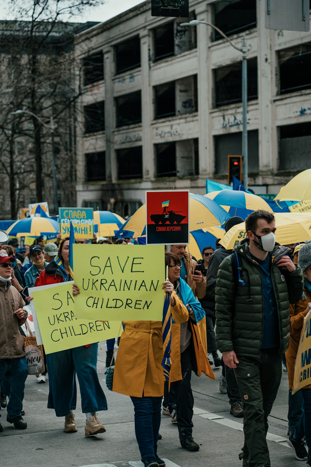 a group of people walking down a street holding signs