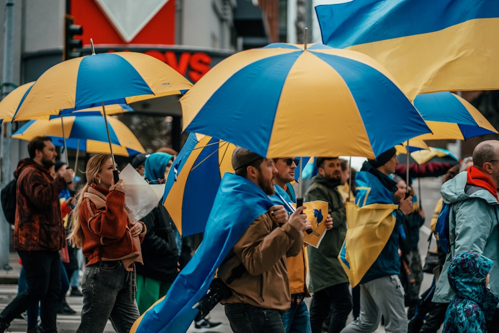 a group of people walking down a street holding umbrellas