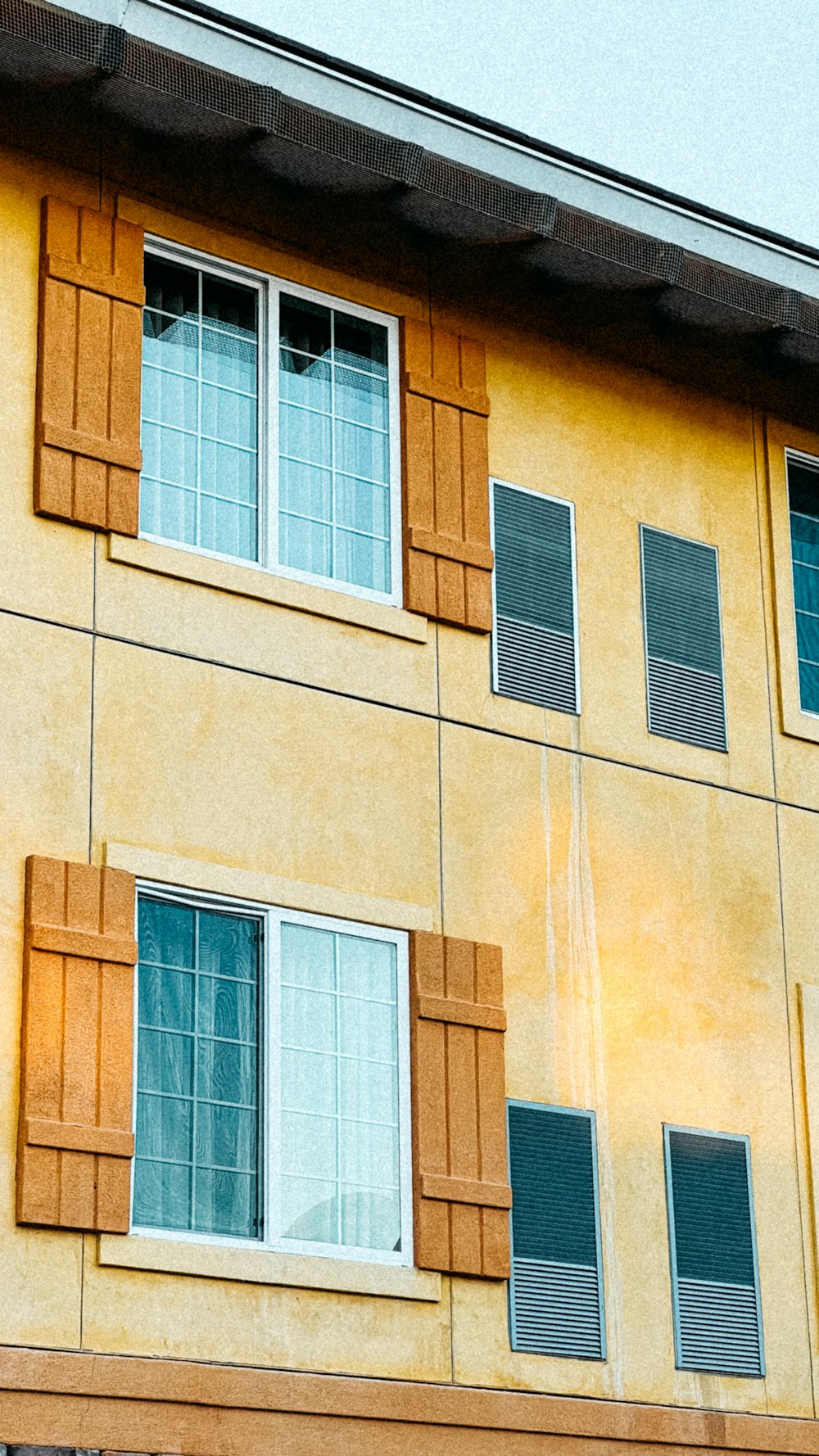 a yellow building with a clock on the side of it