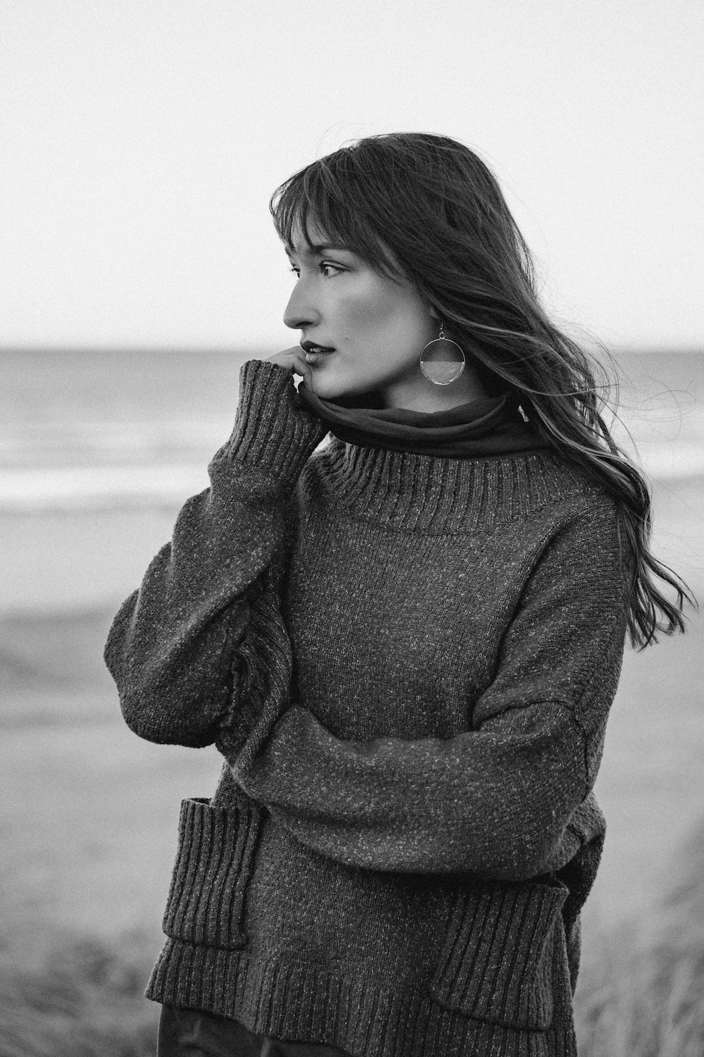 a woman standing on a beach next to the ocean