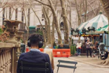 A serene outdoor photo of Andy sitting on a park bench, headphones on, lost in the music.