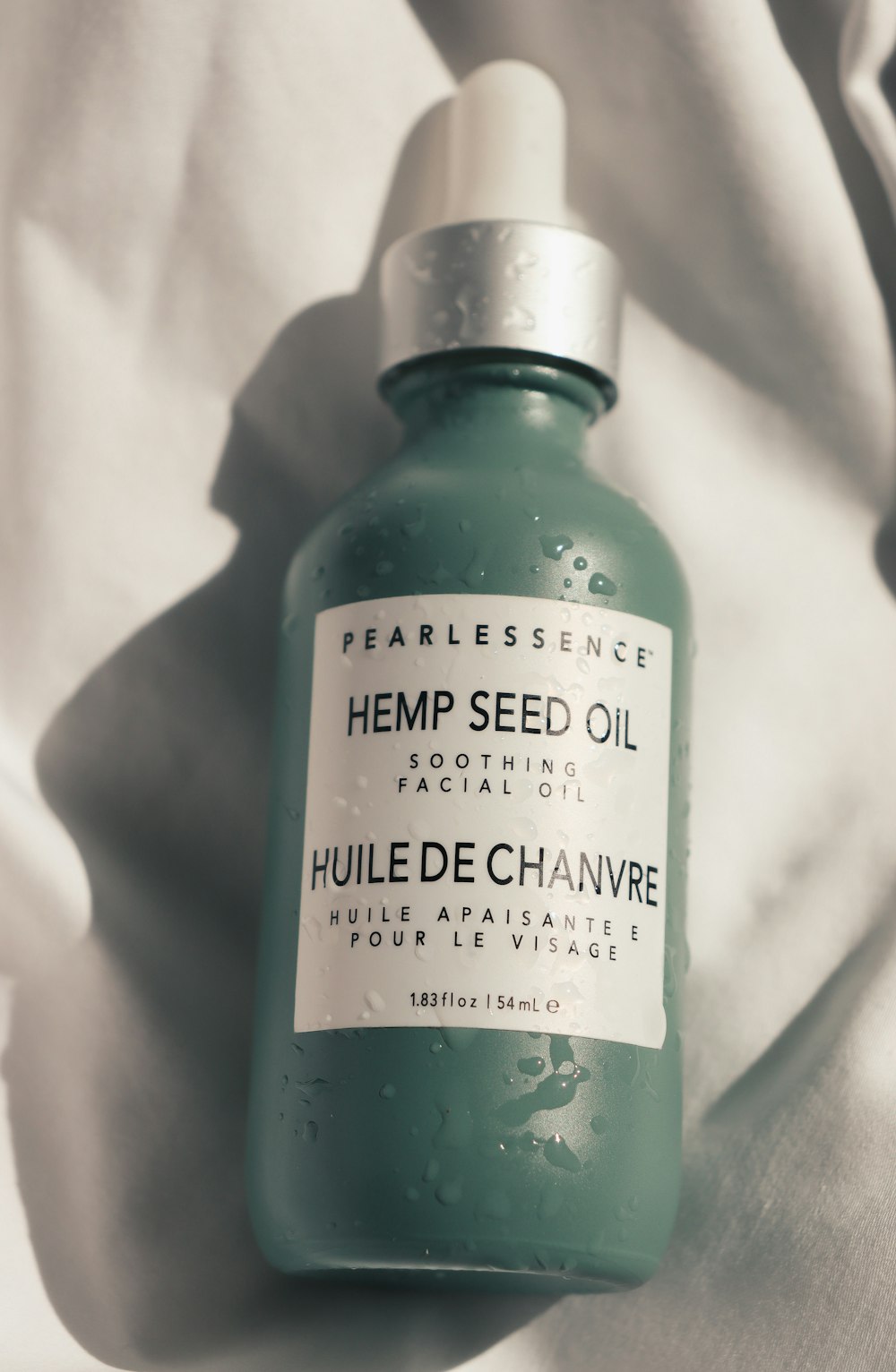 a bottle of hemp seed oil sitting on a bed