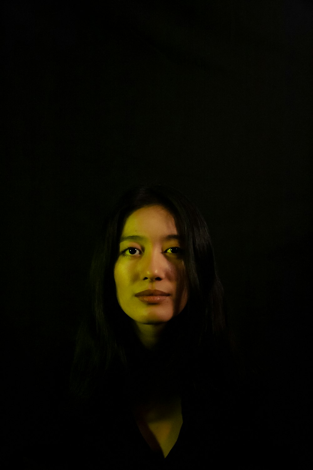 a woman in a dark room with a black background