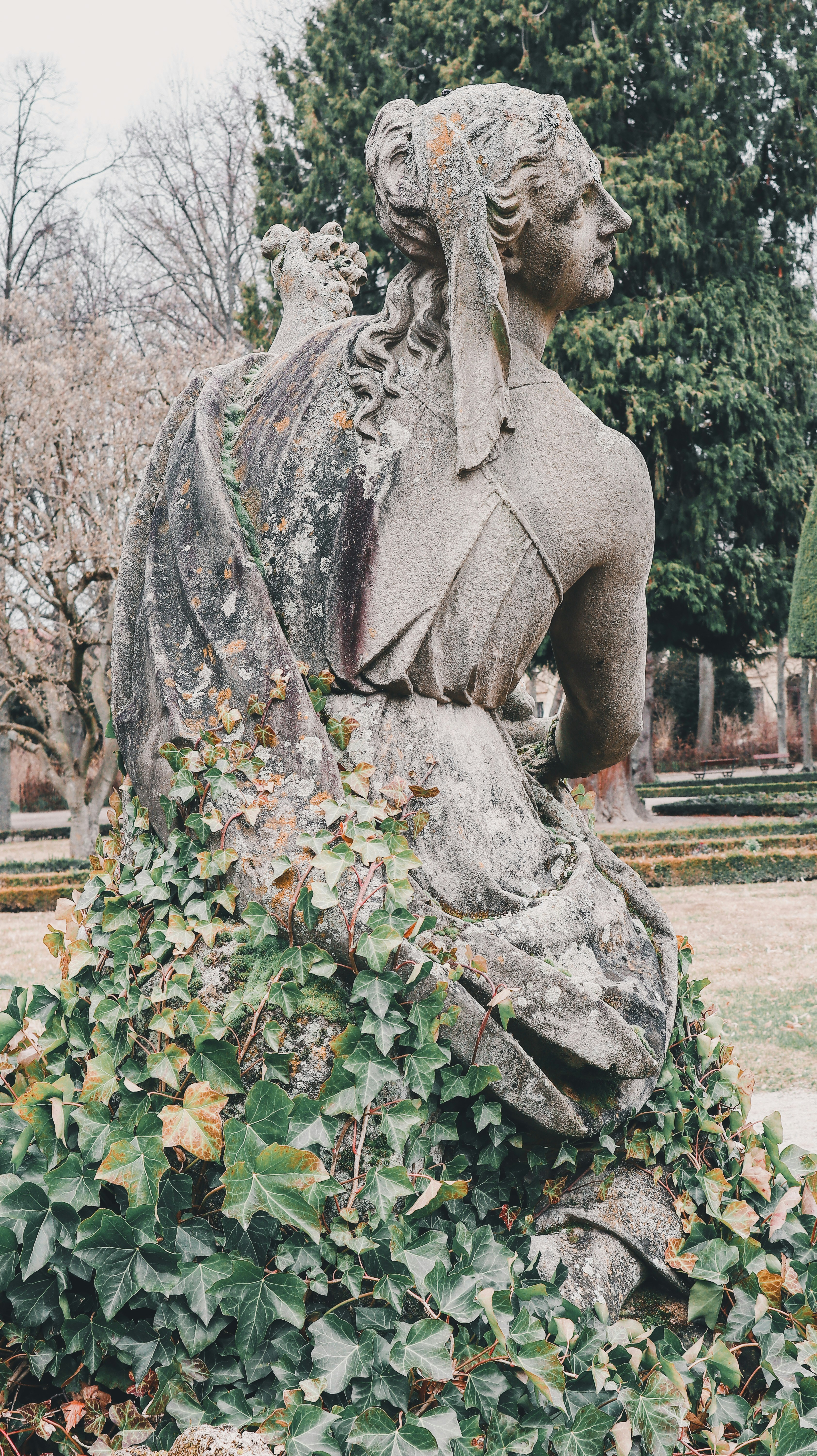 Una estatua de una mujer sentada en la cima de una roca