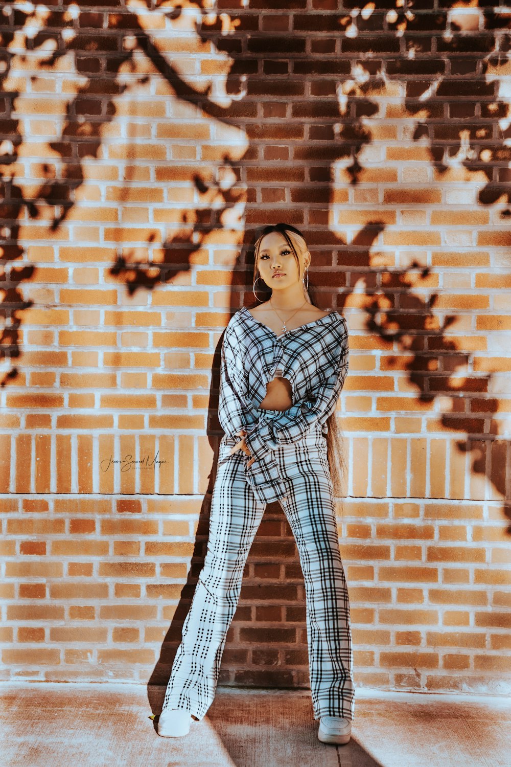 a woman standing in front of a brick wall