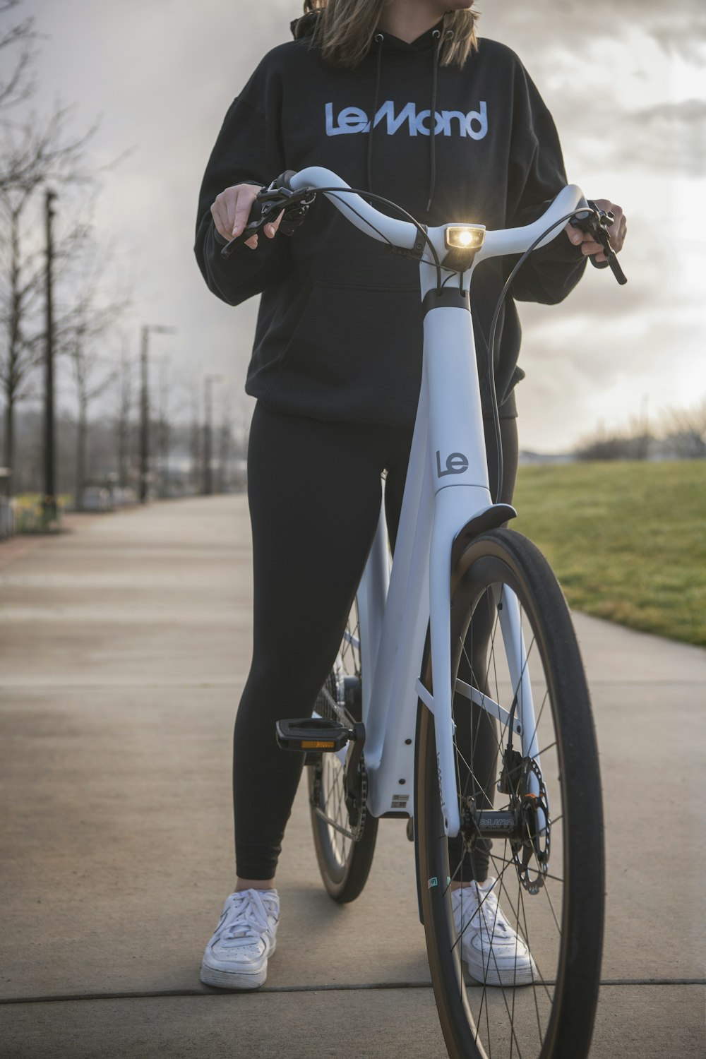 a woman standing next to a white bike