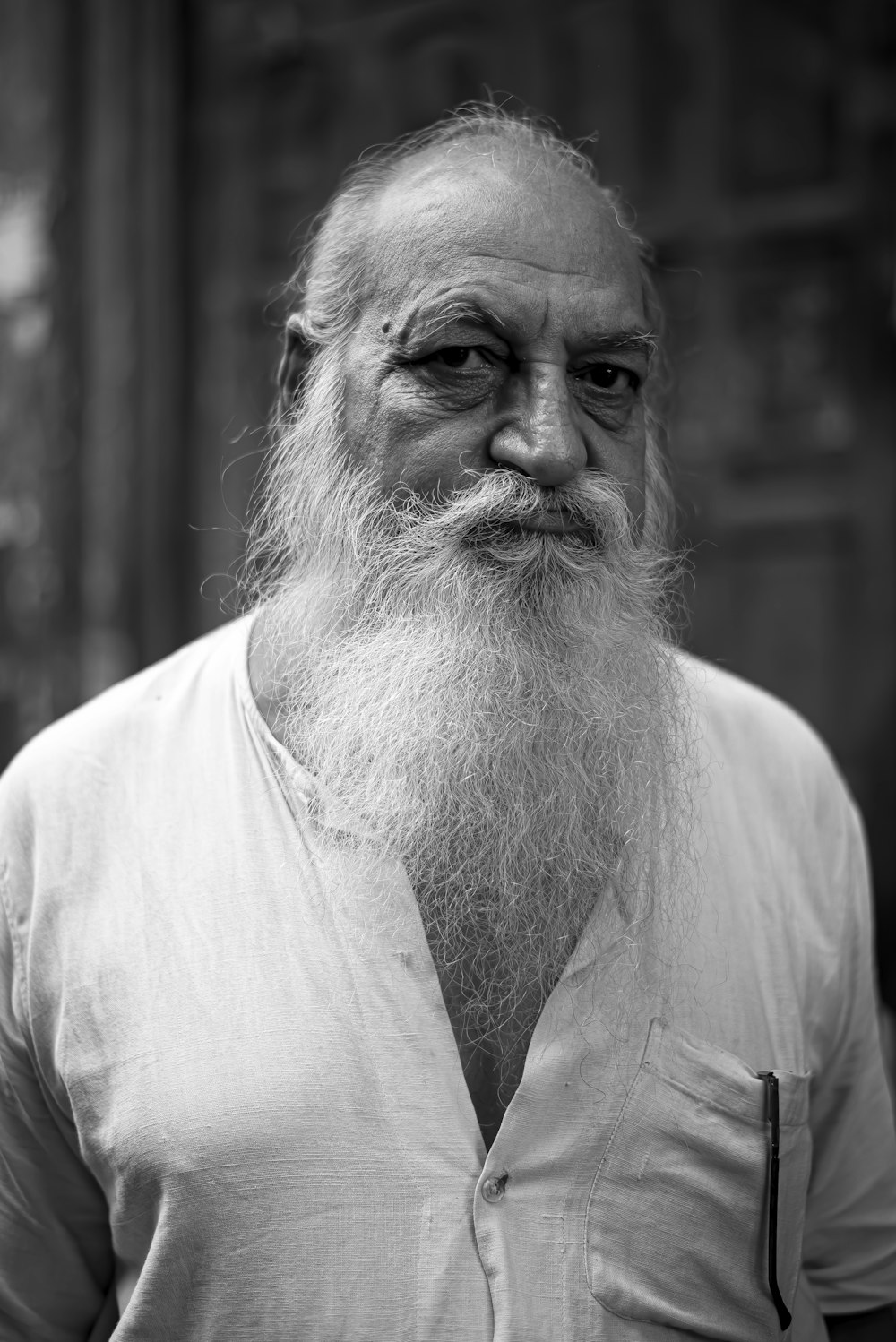 a black and white photo of a man with a long white beard