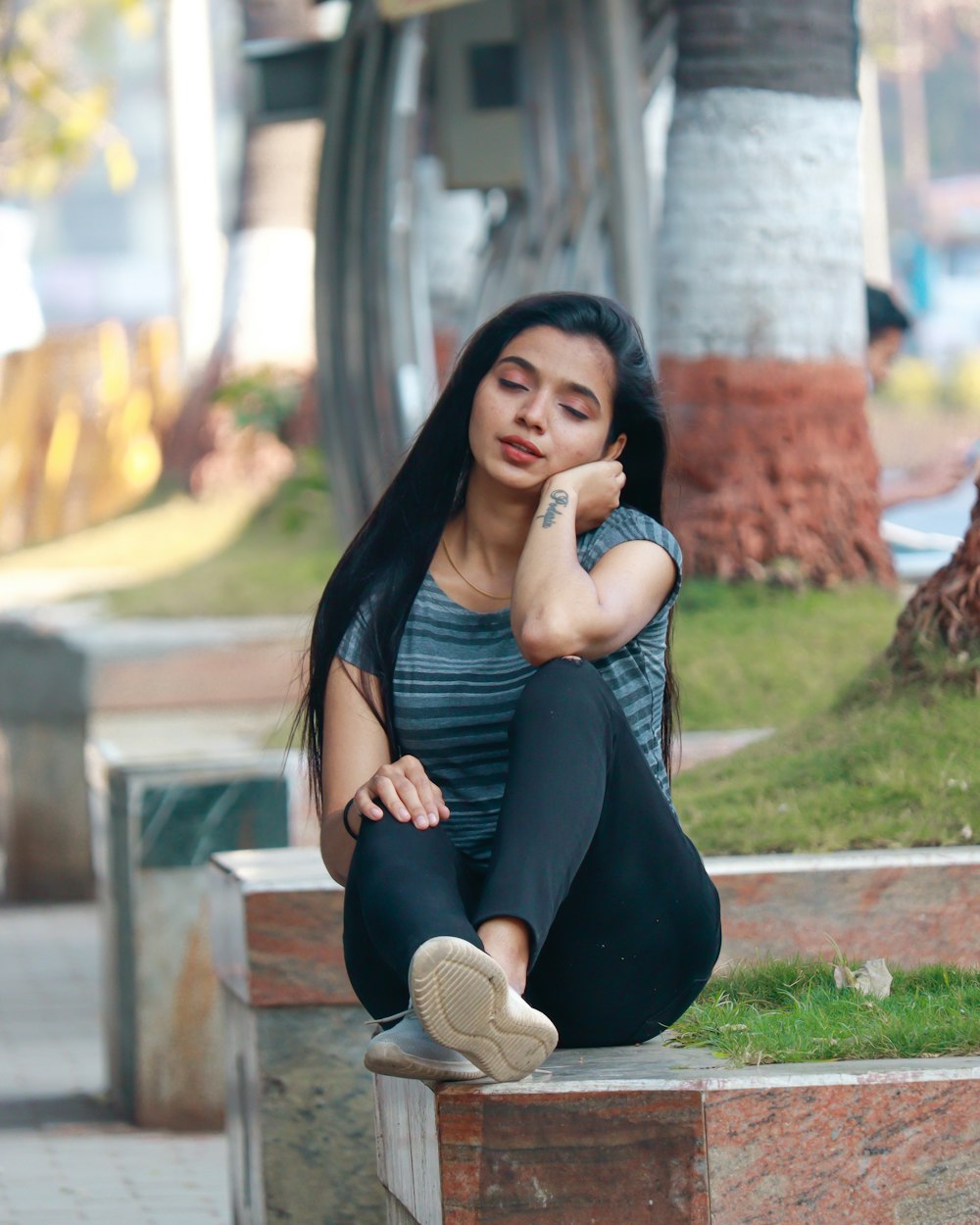 a woman sitting on the ground with her legs crossed