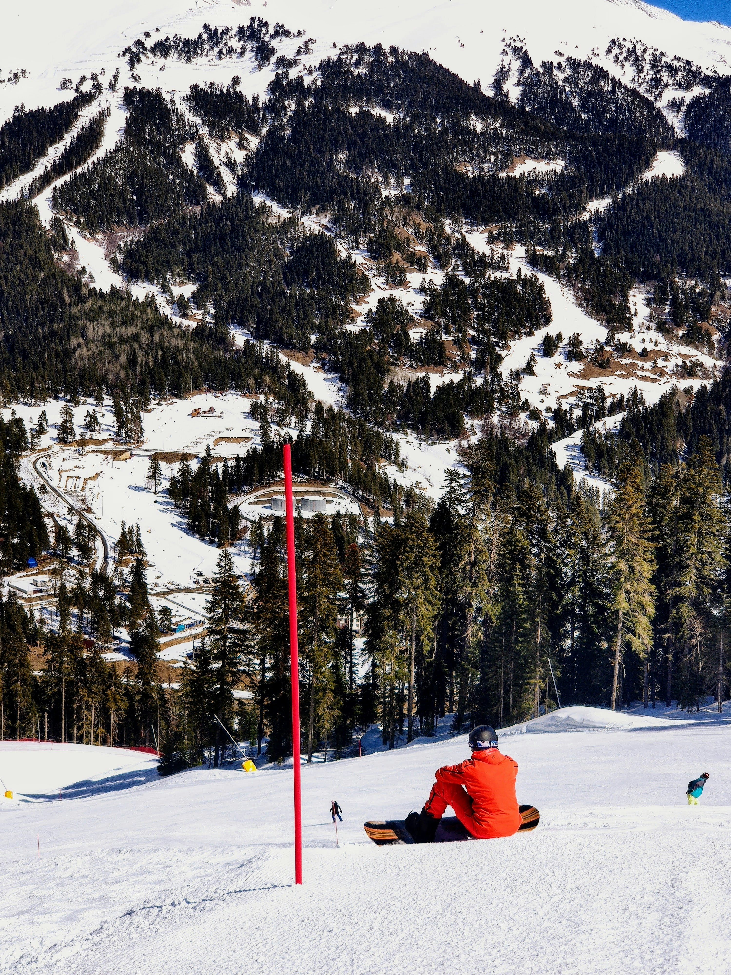 a man sitting on top of a snow covered slope