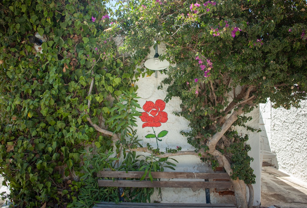 a bench in front of a wall with flowers on it