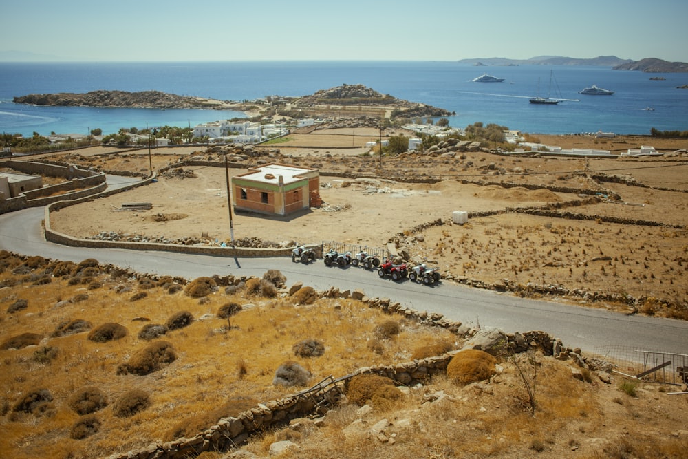 a group of cars driving down a road next to a body of water