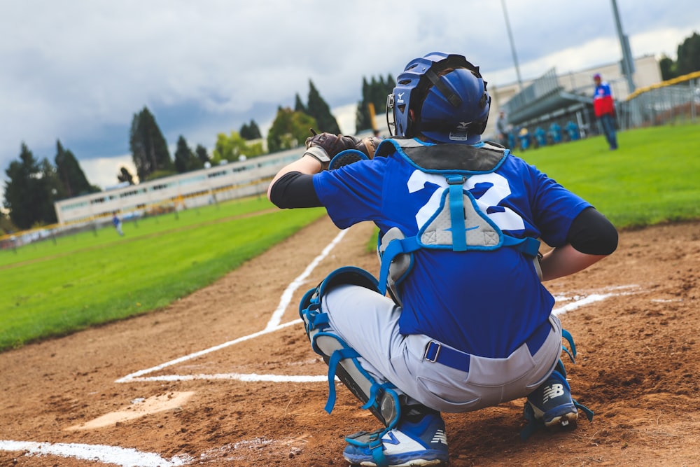 a baseball player sitting on the ground with a bat