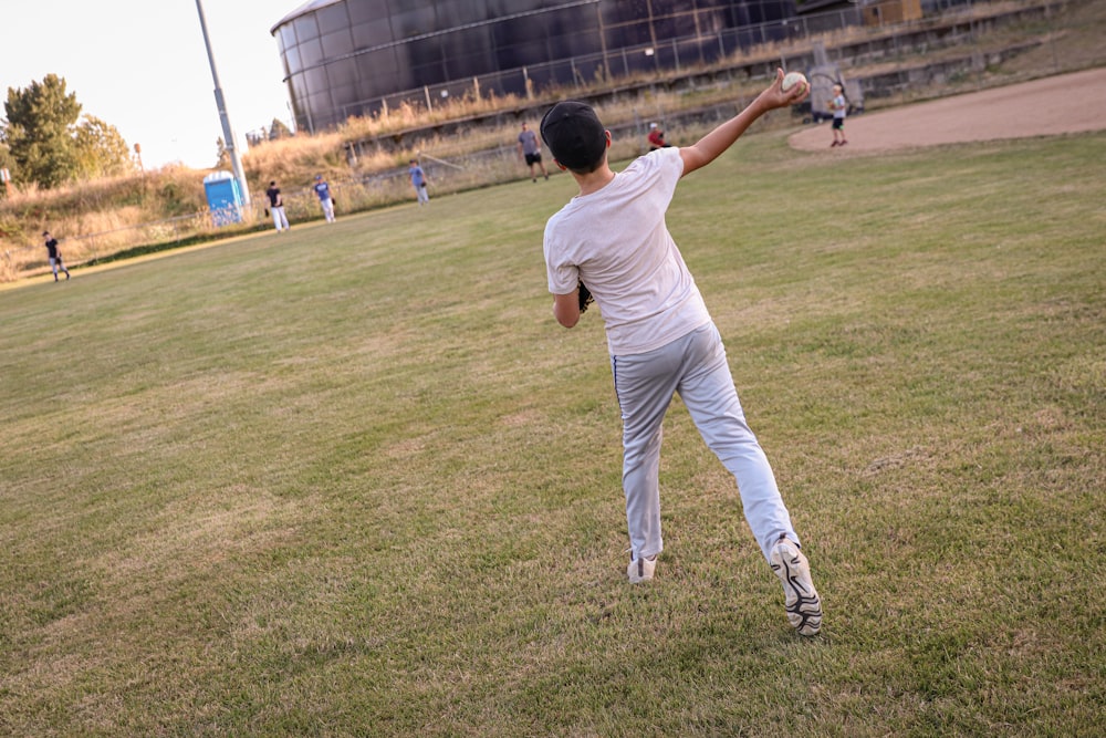 a man throwing a baseball in a field