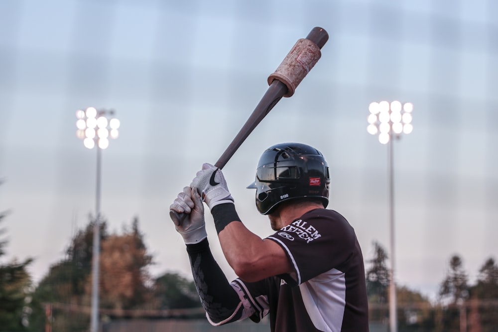 a man holding a baseball bat on top of a field