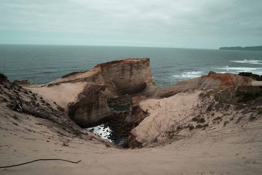 a sandy beach with a body of water in the distance