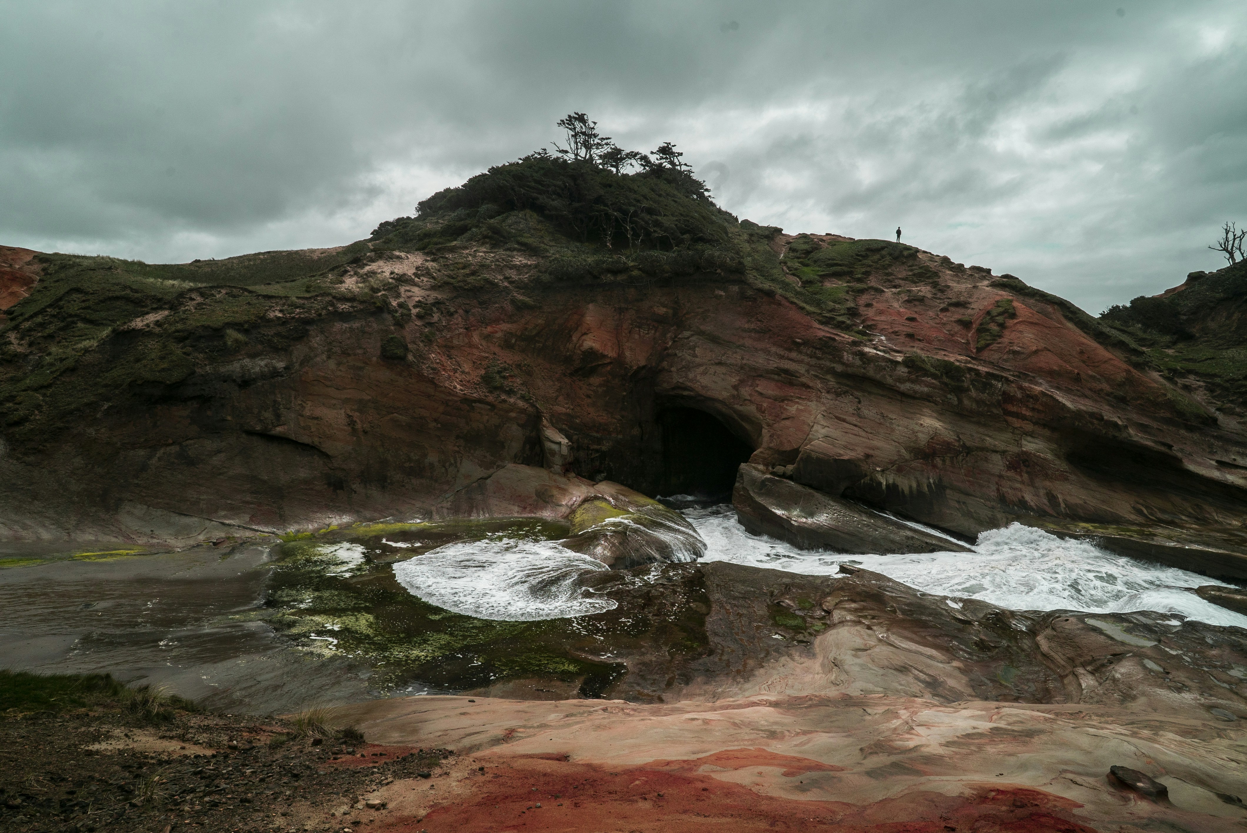eine felsige Klippe mit einer kleinen Höhle in der Mitte
