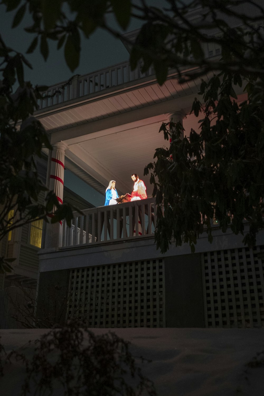 two people standing on a balcony at night