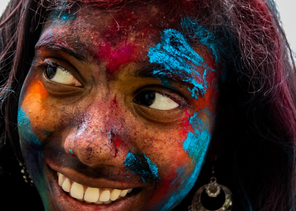 a close up of a woman's face with paint all over her face