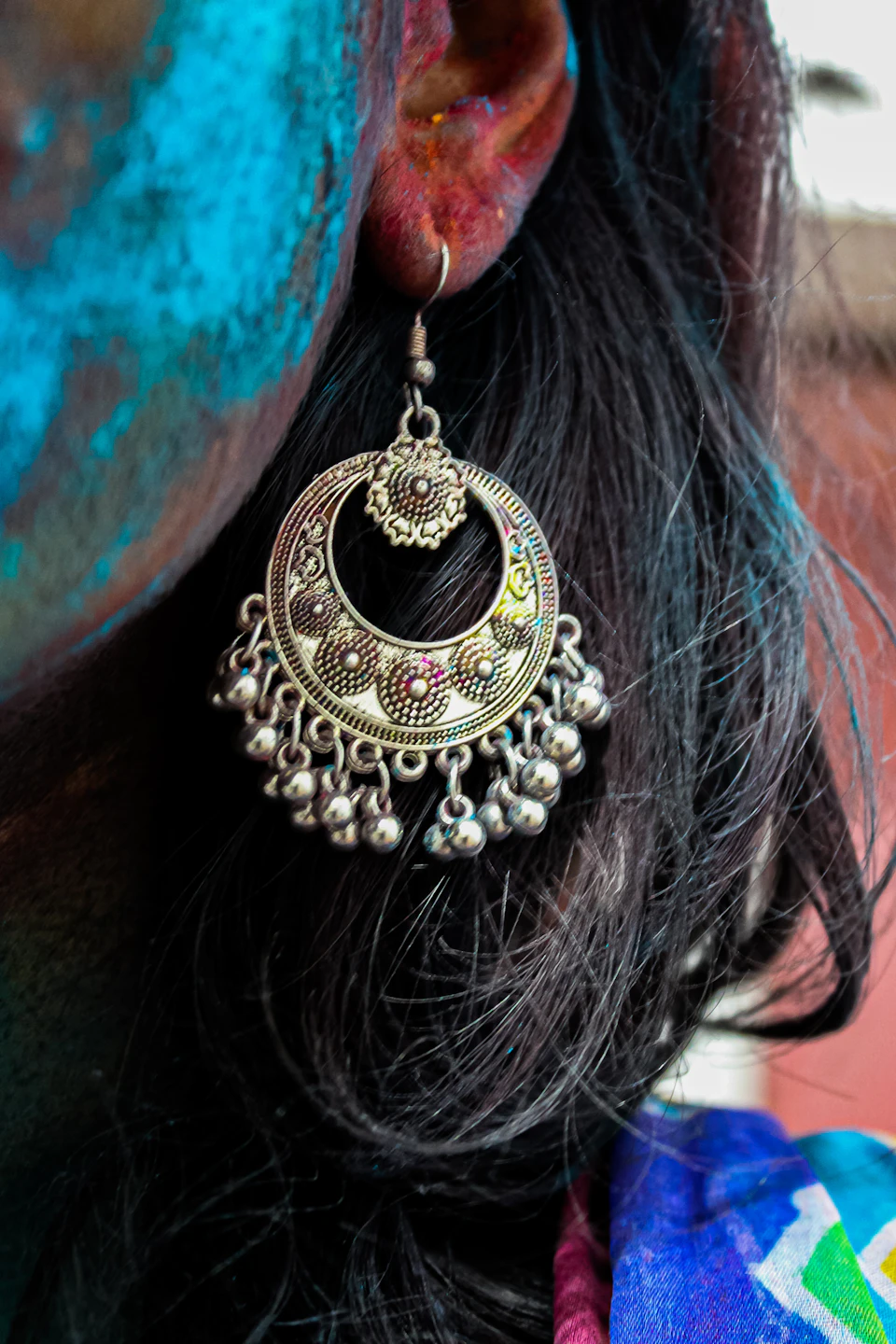 a close up of a person wearing a pair of earrings