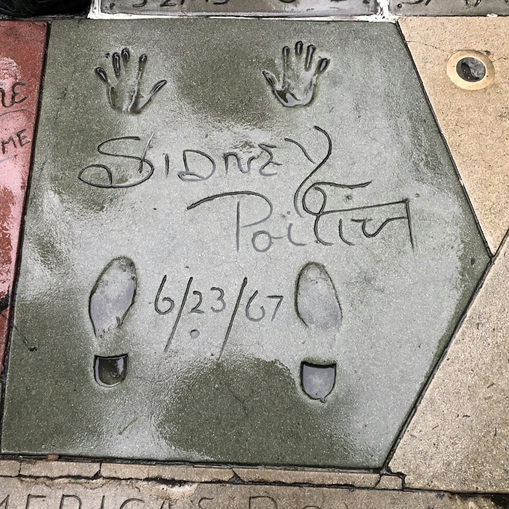 a sidewalk with a hand and foot prints on it