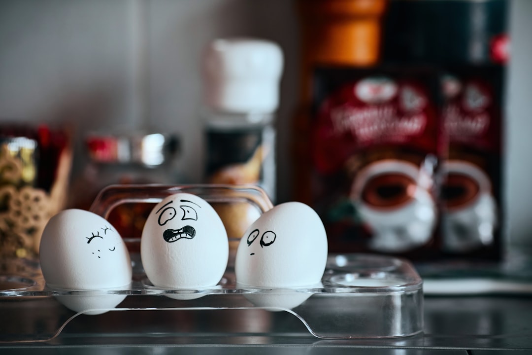 three eggs with faces drawn on them sitting on a counter, Emotional chicken eggs - cheerful, surprised, devastated and depressed. Background for a website about psychological support or articles about human psychology. Food and psychology - a splash screen for social networks