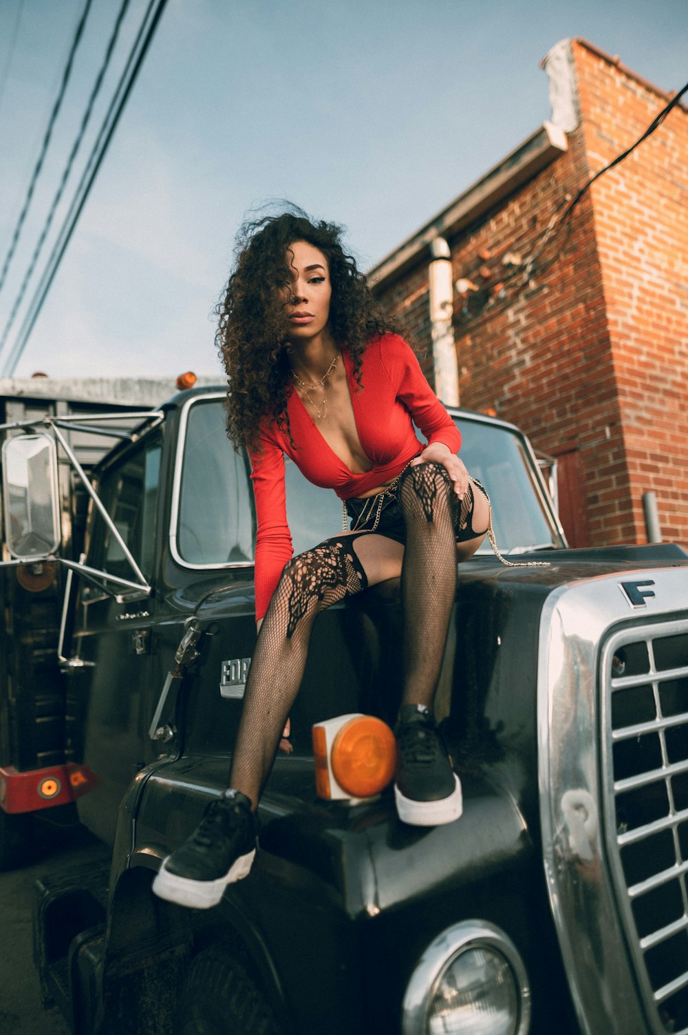 a woman sitting on the hood of a truck