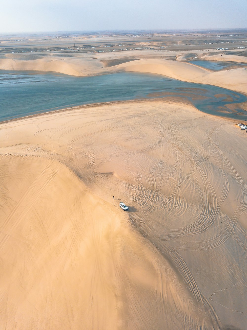 an aerial view of a sandy beach and a body of water