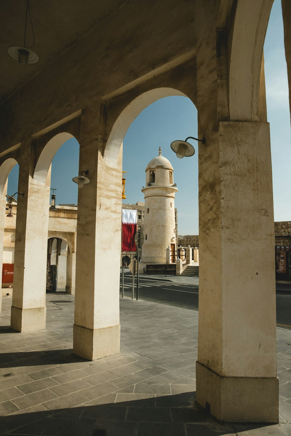 a building with arches and a clock tower in the background