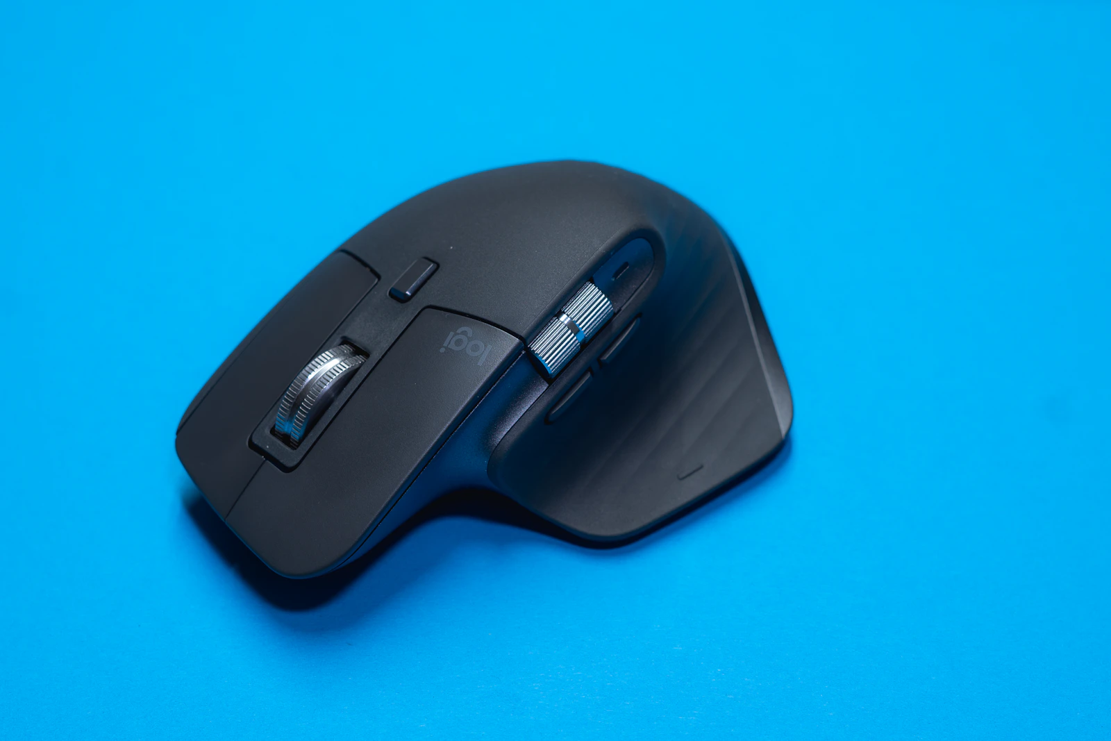 Black Logitech MX Master mouse on blue