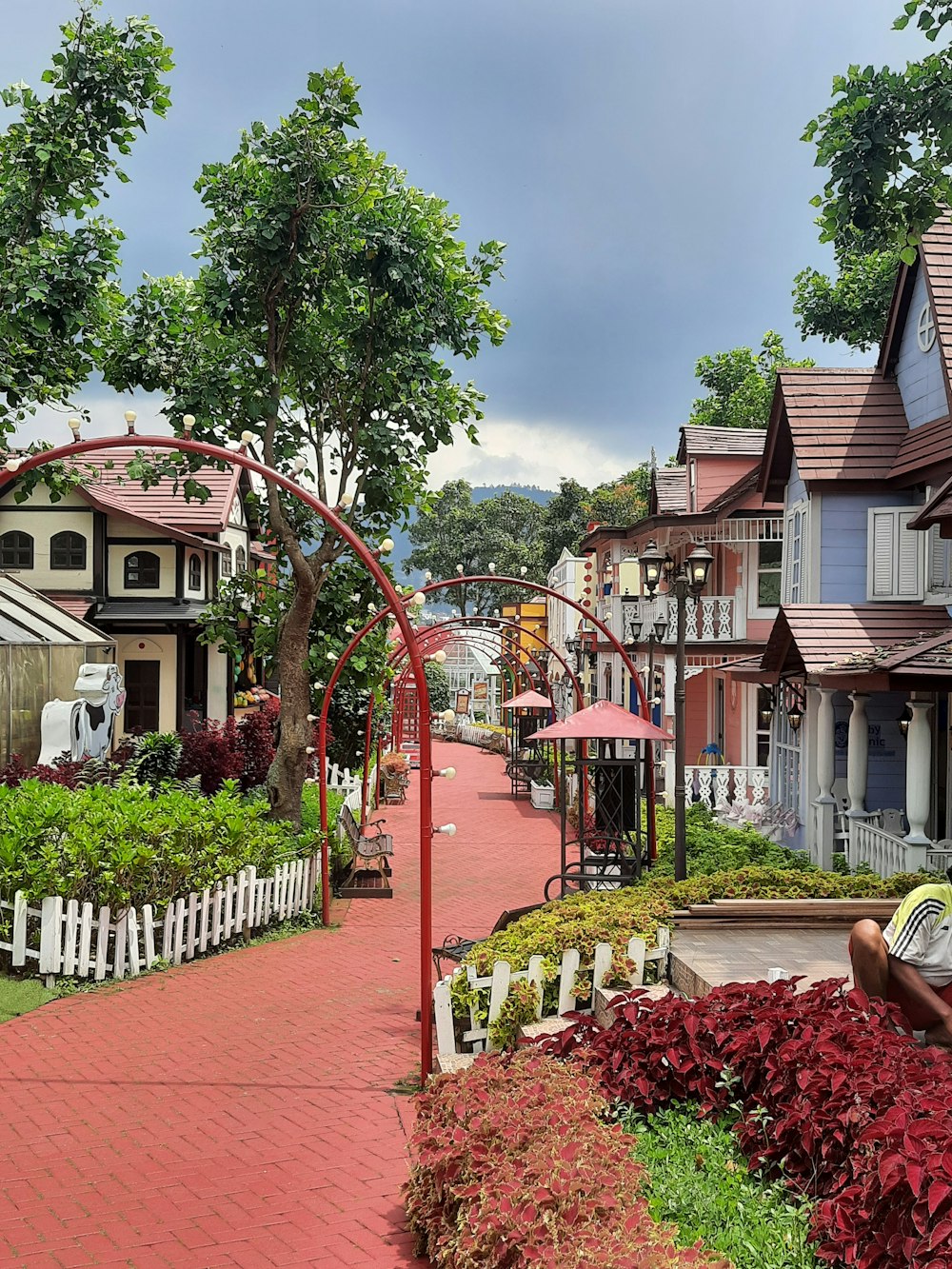 a woman sitting on a bench in front of a row of houses