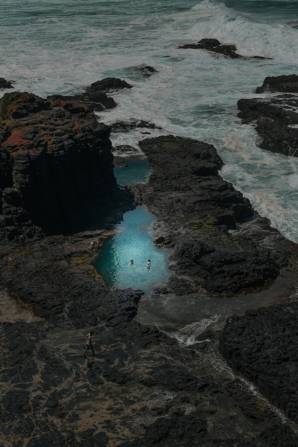 a body of water surrounded by rocks near the ocean