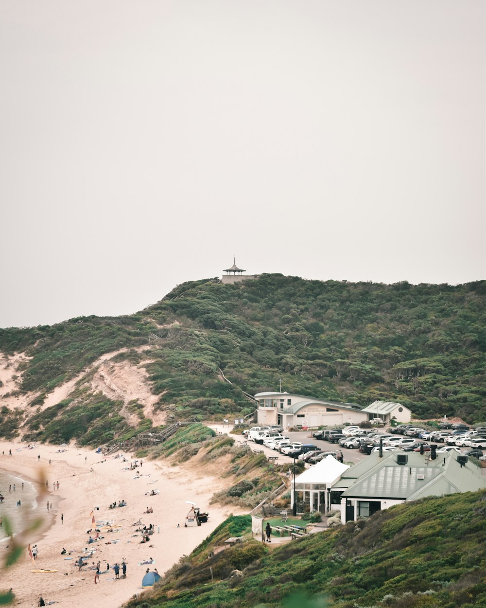 a group of people standing on top of a sandy beach