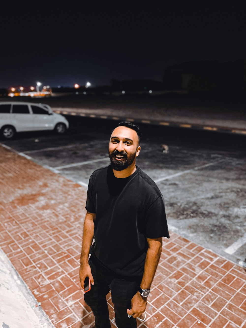 a man standing in a parking lot at night