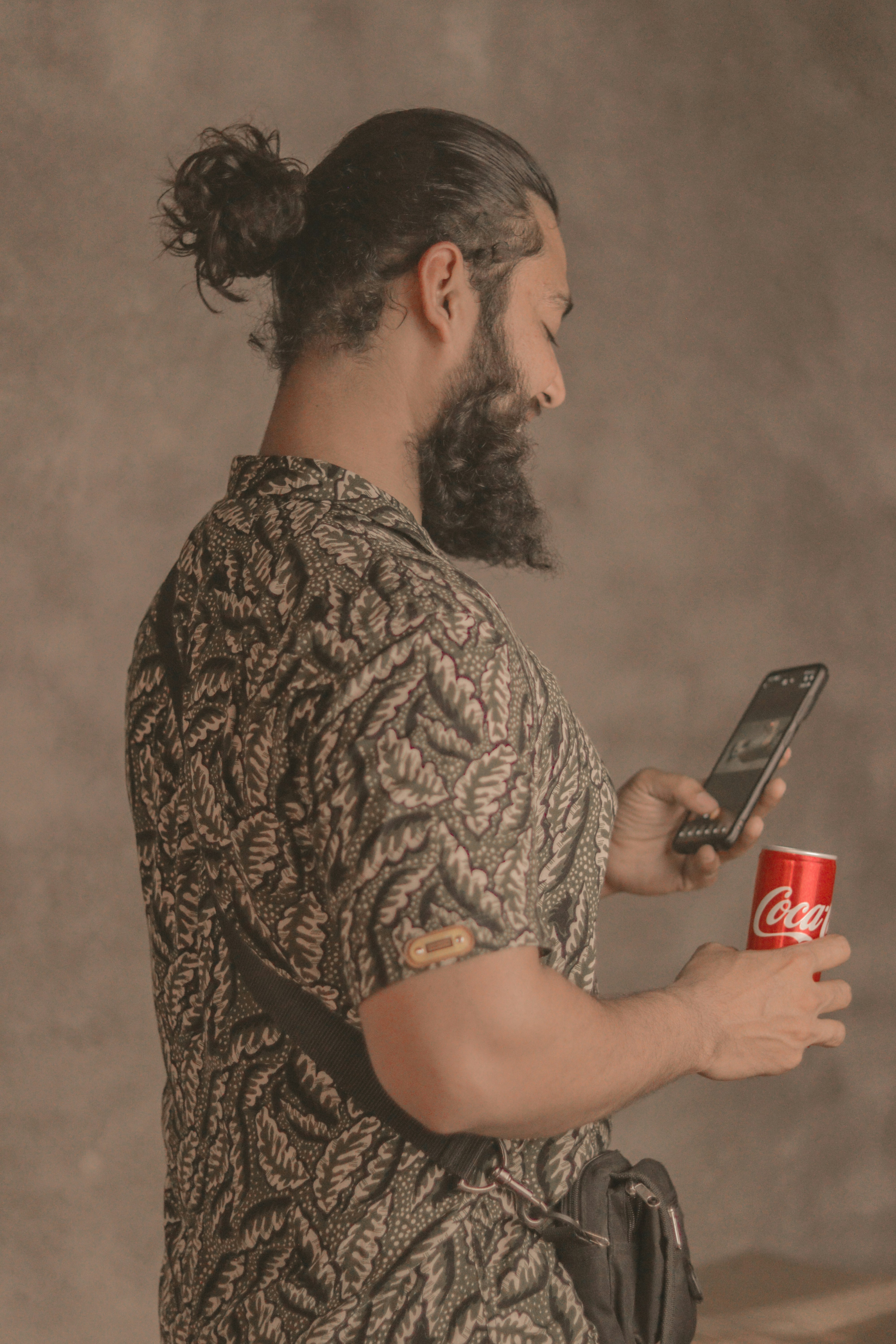 A man with a beard holding a can of coke and a cell phone photo – Free ...