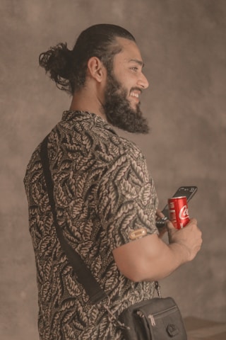 a man with a beard holding a cell phone