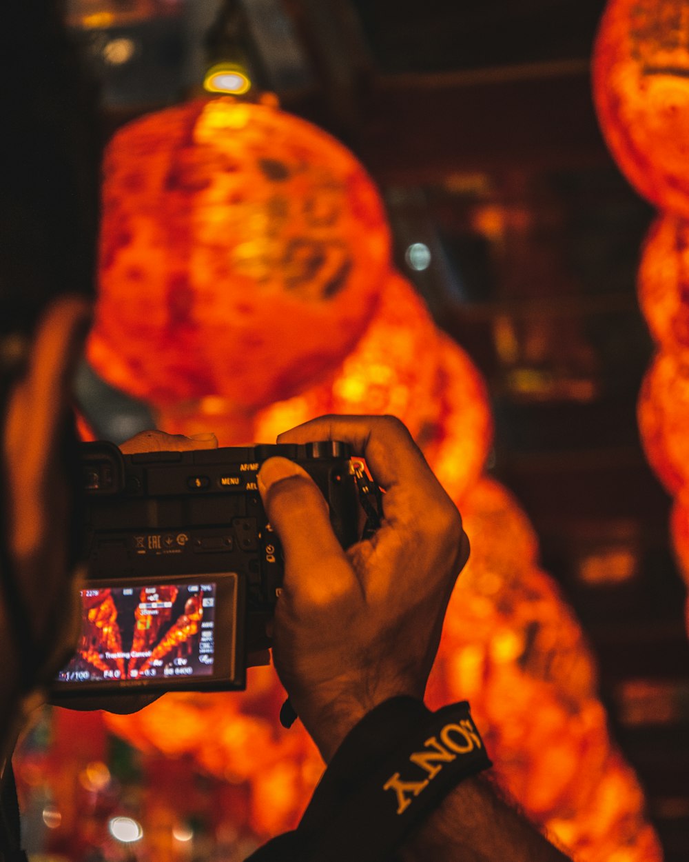 a man holding a camera in front of a display of lights