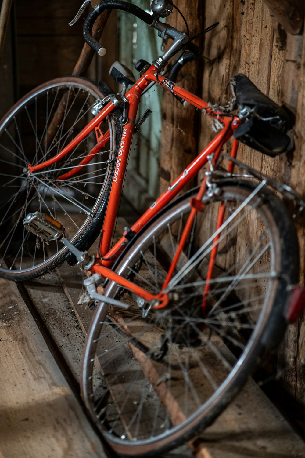 a red bicycle parked on a wooden bench