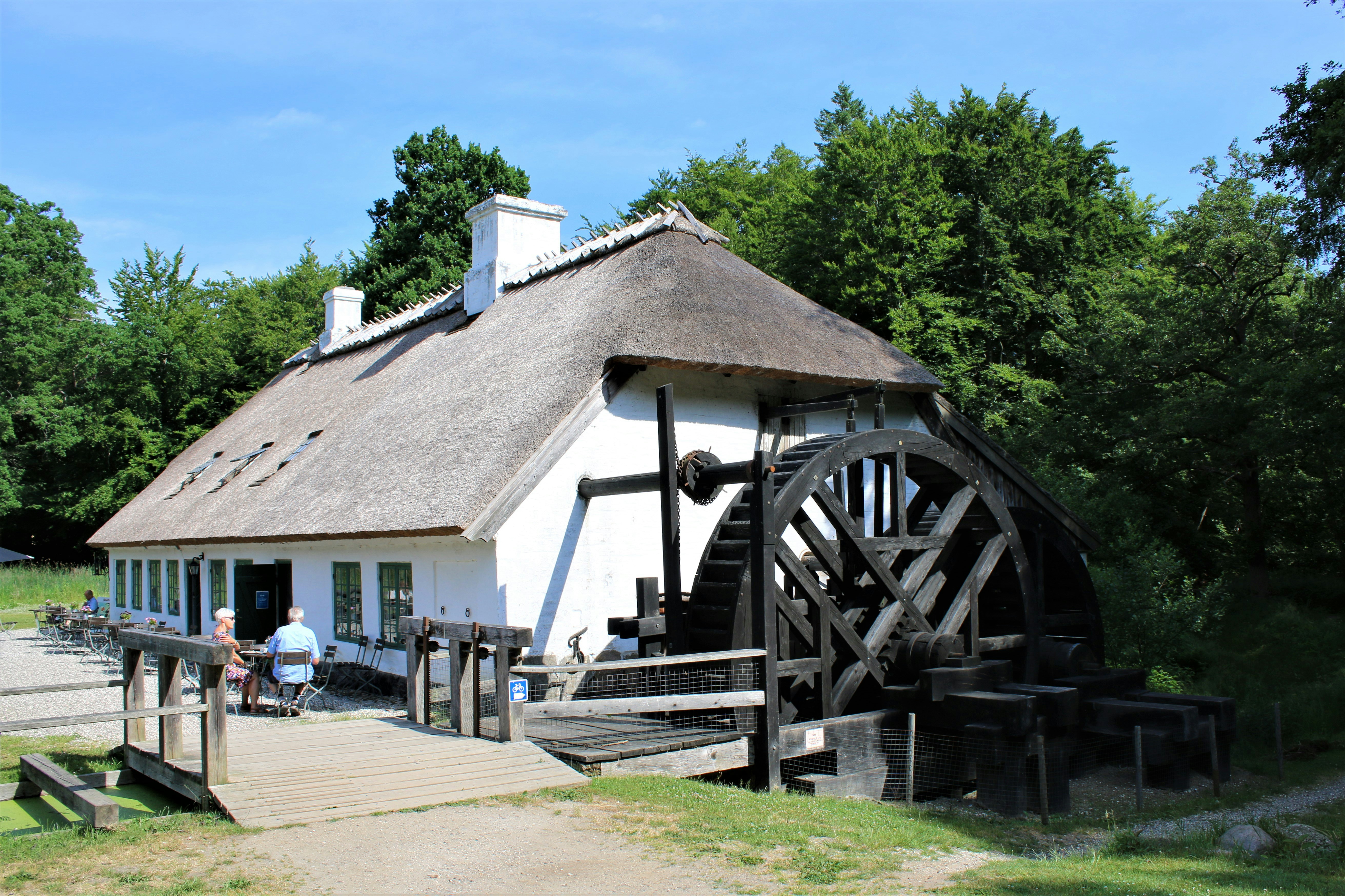 Stop image for Natchez to Nashville: Southern Heritage & Scenic Highways Weekend - a white house with a thatched roof and a water wheel -  in Mississippi, Alabama, Tennessee - Photo by Pramod Kumar Sharma on Unsplash