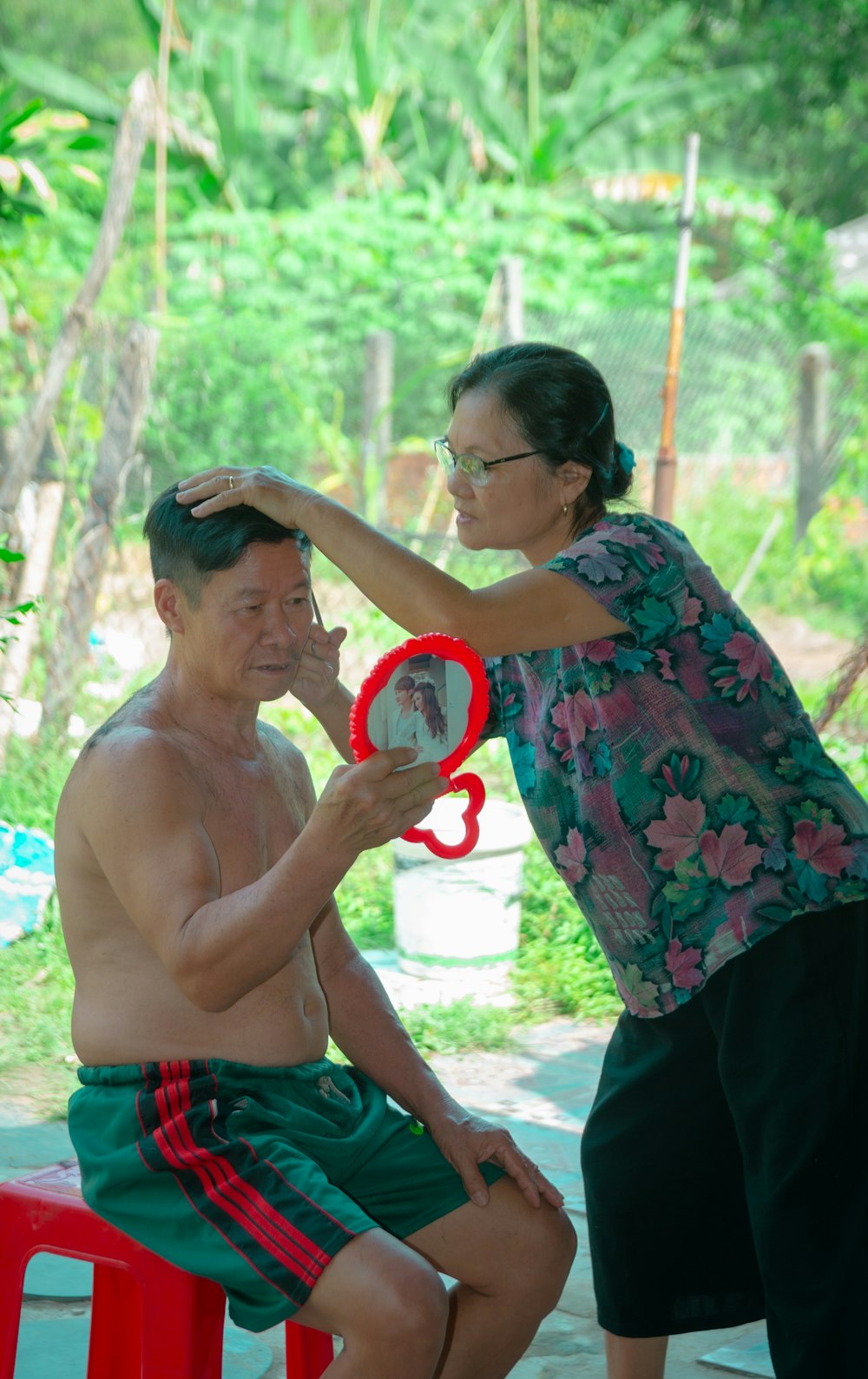 a man holding a red frisbee next to a woman