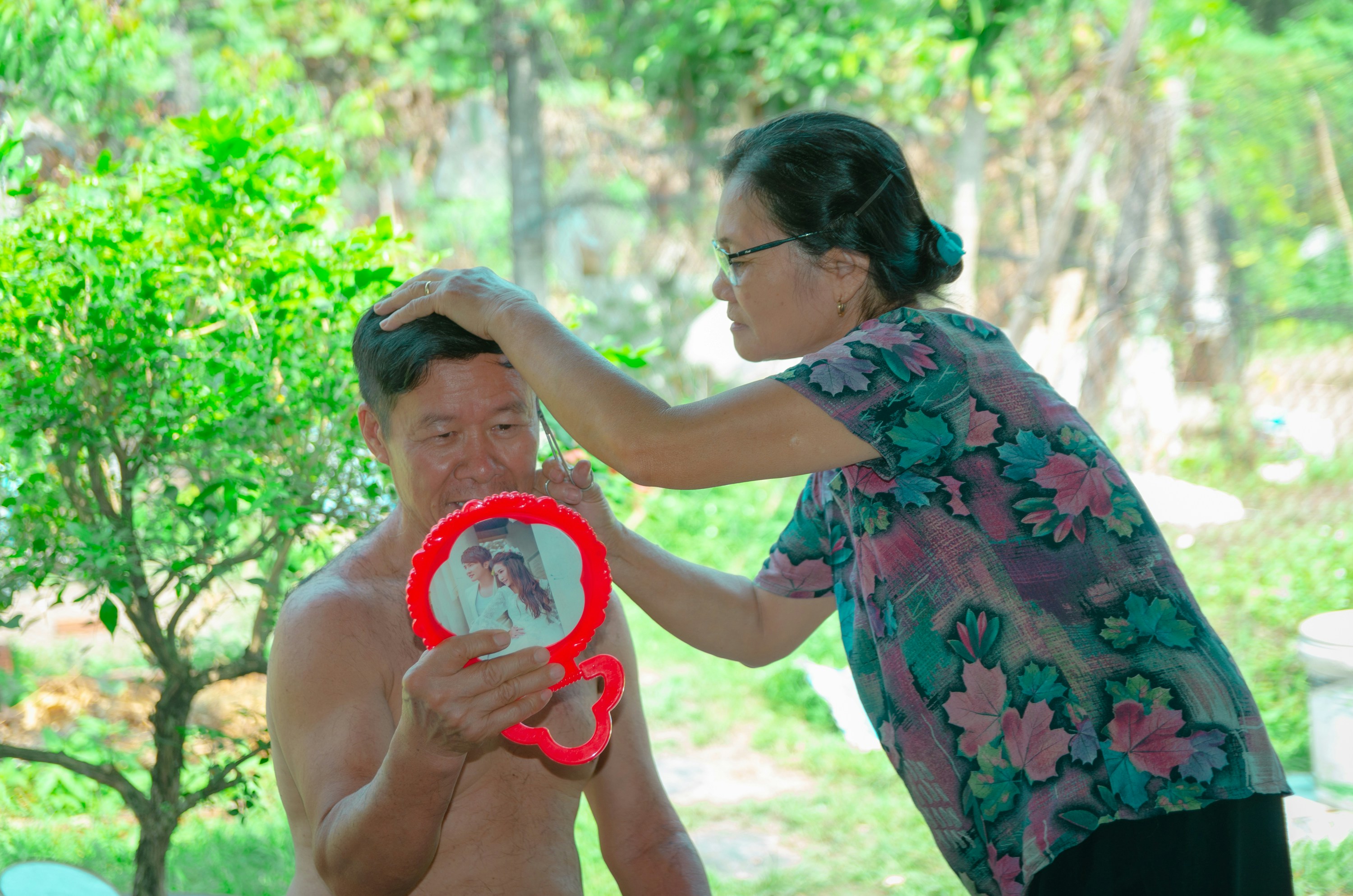 a man holding a red frisbee next to a woman