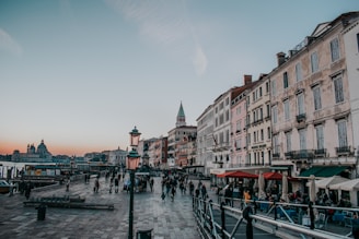 A scenic European cityscape with historic buildings and cobblestone streets at sunset.