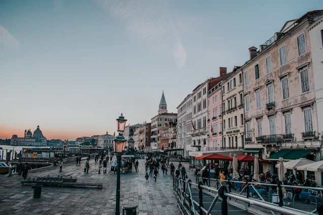 Happy travelers exploring a famous European city square during sunset.