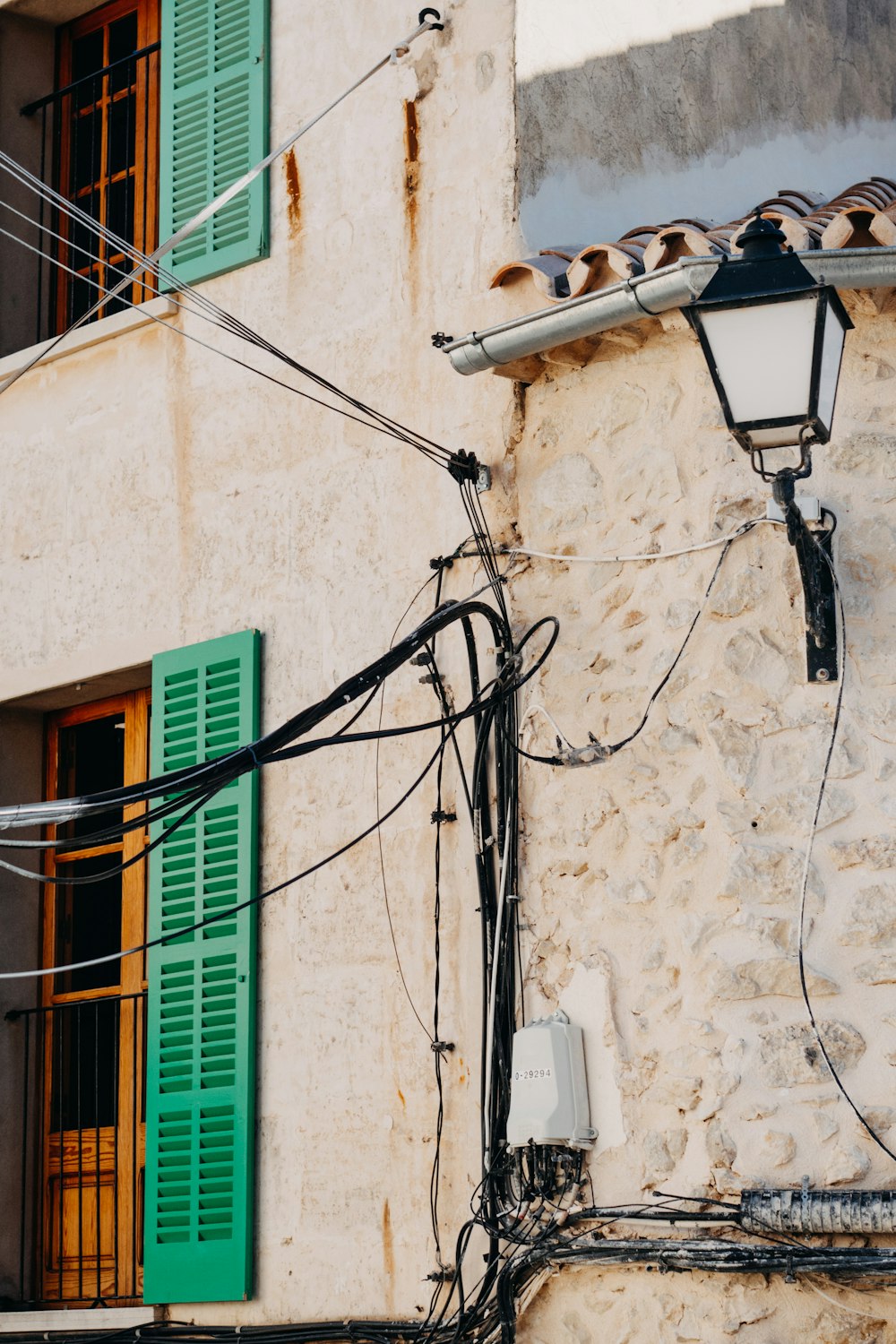 a building with green shutters and a street light