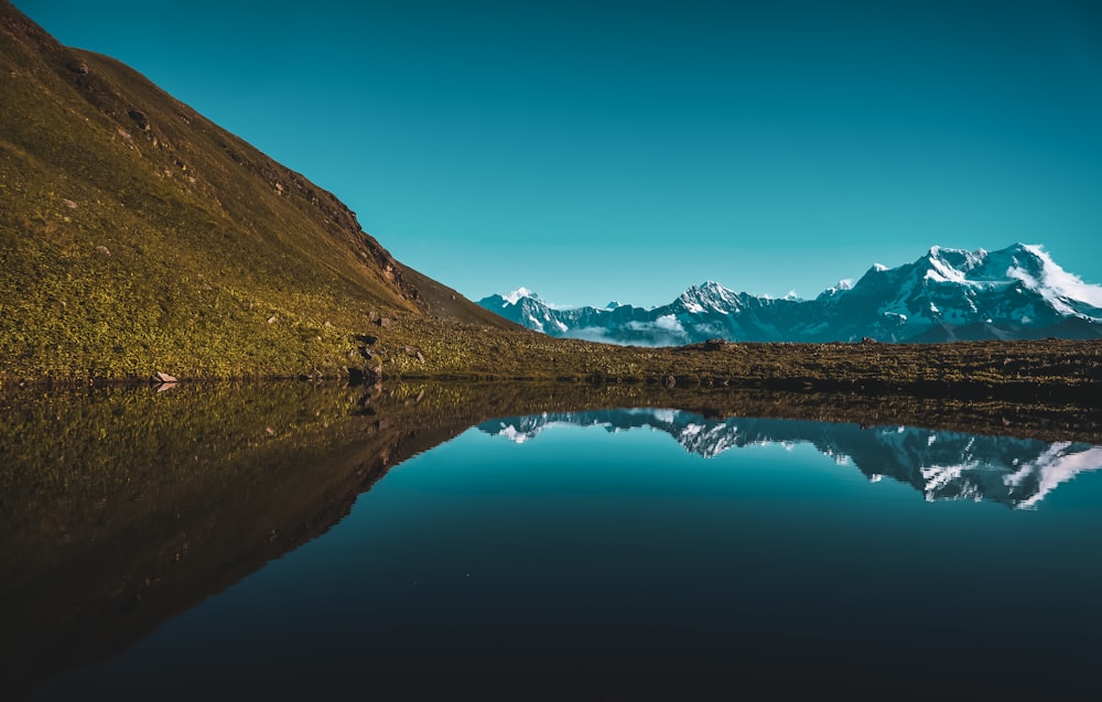 a large body of water with a mountain in the background